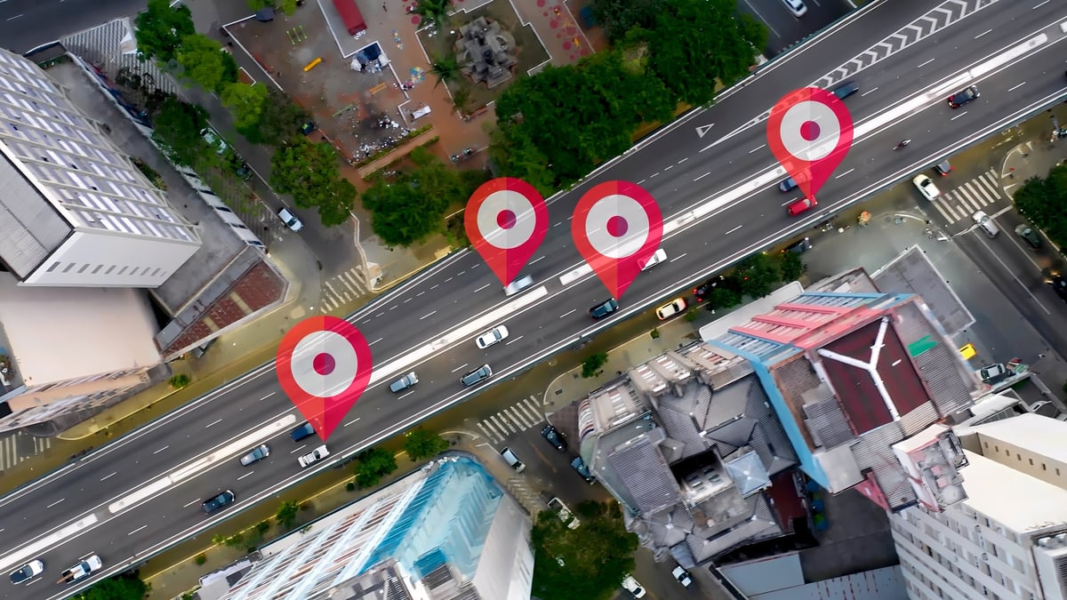 Aerial cityscape of a smart city with a futuristic GPS location marker icon representing geolocation, connection and data analysis technology