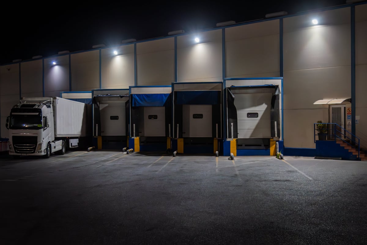Loading docks of a warehouse with a refrigerated truck parked at night, logistics operation