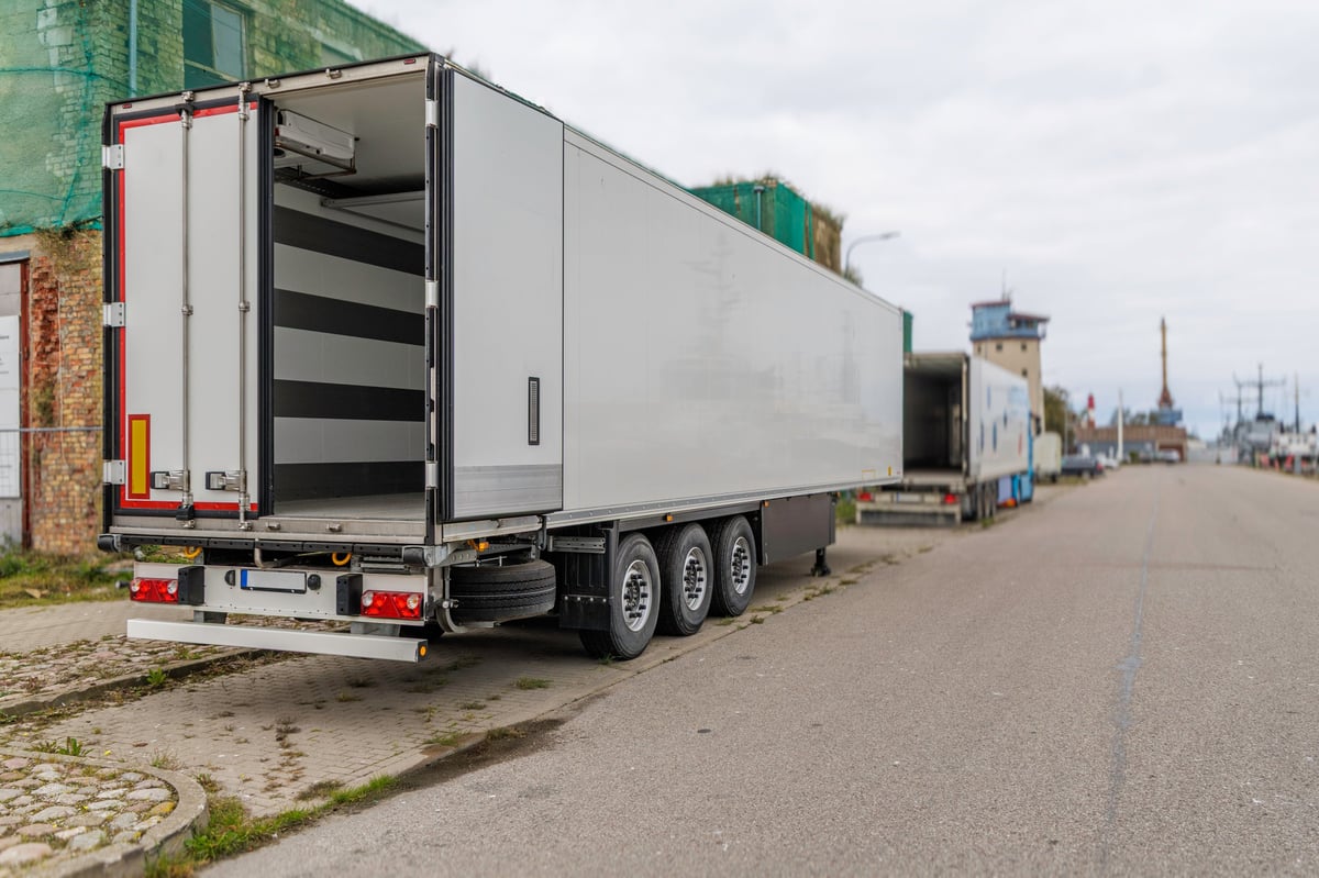 Rear view of a large white refrigerated semi-trailer with its doors open